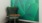 room with table and chair and green wallpaper